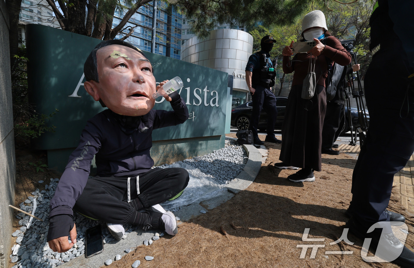 (서울=뉴스1) 박세연 기자 = 11일 윤석열 전 대통령 사저인 서울 서초구 아크로비스타 앞에 윤 전 대통령을 반대하는 한 시민이 윤 전 대통령 탈을 쓰고 앉아있다.윤 전 대통령은 …