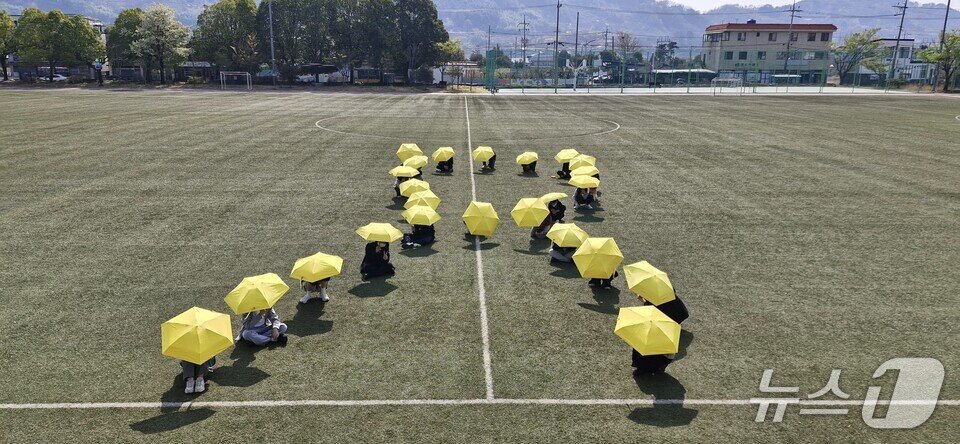 본문 이미지 - 학생들이 학교 운동장에서 노란우산을 펼치고 세월호 참사를 추모하고 있다.&#40;전남도교육청 제공, 재판매 및 DB 금지&#41;