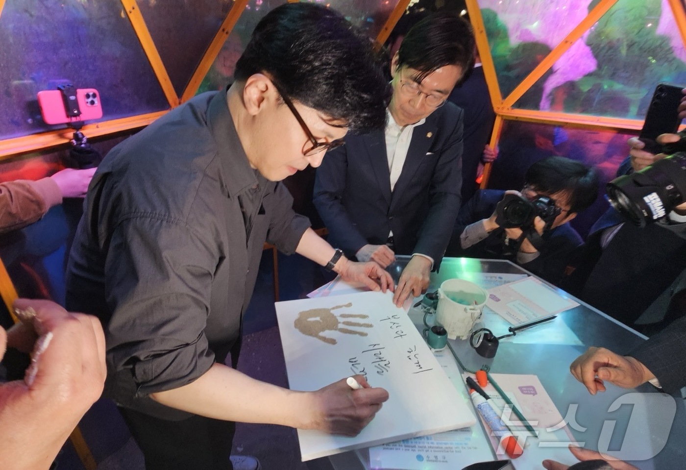 (부산=뉴스1) 장광일 기자 = 한동훈 전 국민의힘 대표가 11일 부산 광안리해수욕장에 마련된 느린 우체통에서 손도장을 찍은 뒤 메시지를 적고 있다.2025.4.11/뉴스1