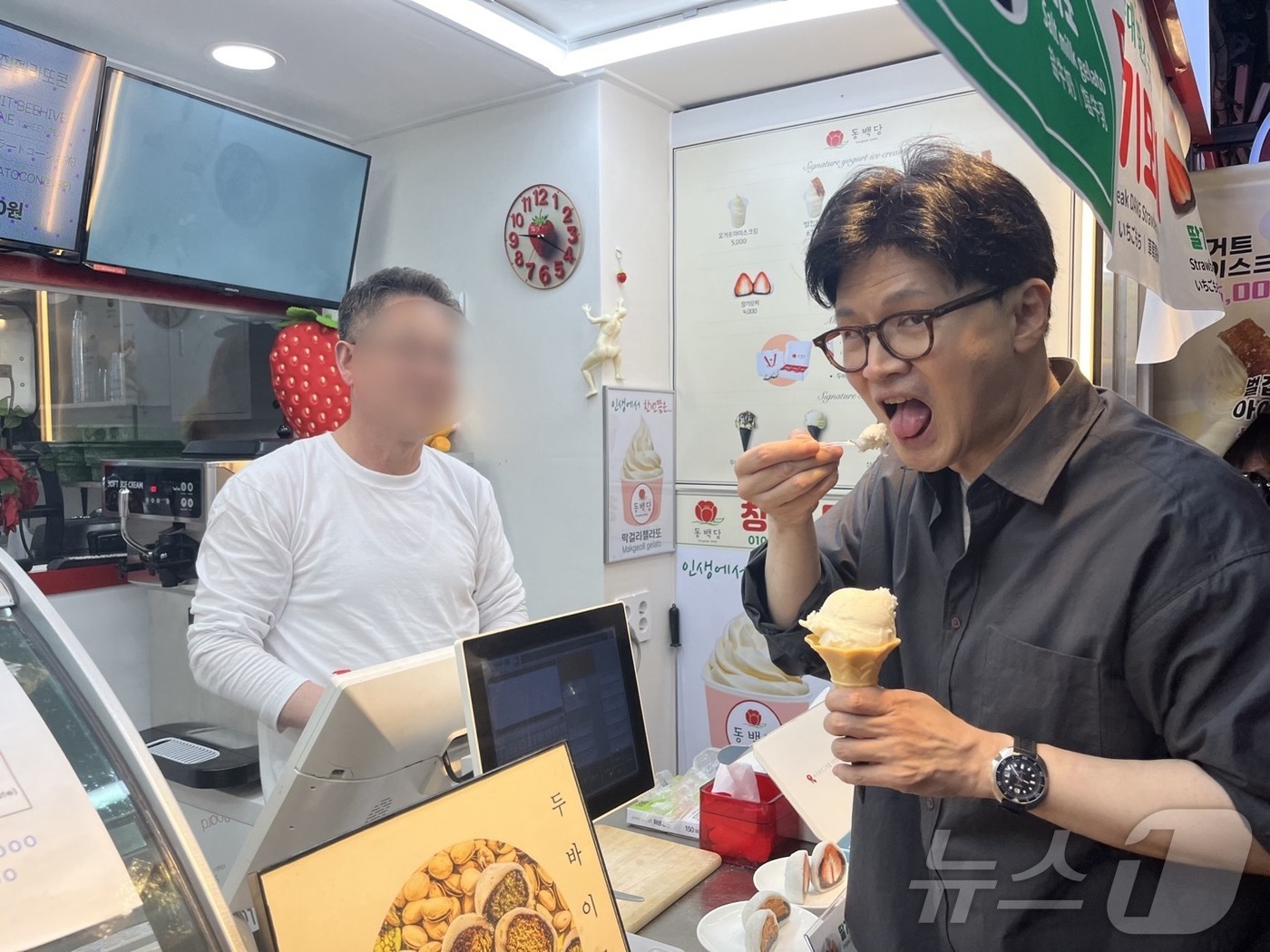 (부산=뉴스1) 장광일 기자 = 한동훈 전 국민의힘 대표가 11일 부산 해운대전통시장에서 아이스크림을 구매한 뒤 먹고 있다.2025.4.11/뉴스1