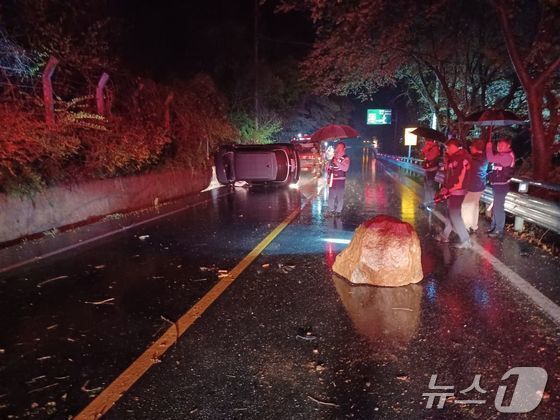 본문 이미지 - 12일 오후 9시 46분쯤 전남 구례군 토지면의 한 도로변에서 바위가 떨어지면서 차가 전도돼 소방당국이 차량에 고립된 운전자 1명을 구조하고 있다. (구례소방 제공. 재판매 및 DB금지)