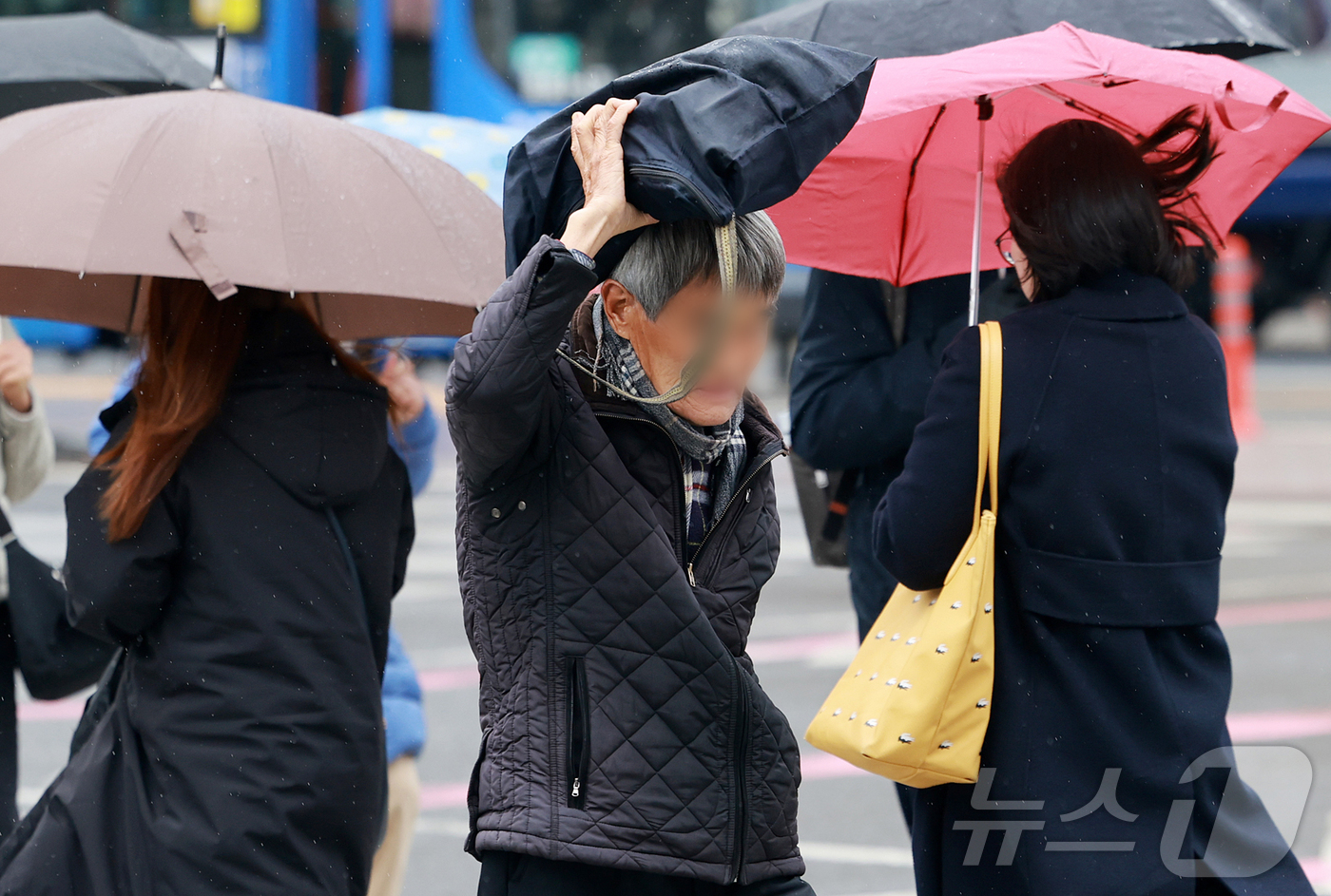 (서울=뉴스1) 김진환 기자 = 14일 오전 서울 종로구 광화문 네거리에서 한 시민이 가방으로 머리를 가린 채 발걸음을 옮기고 있다.기상청은 이날 전국 대부분 지역에 비 또는 눈이 …