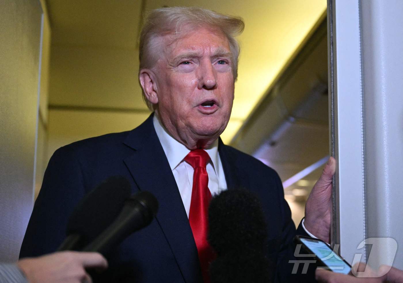 본문 이미지 - 도널드 트럼프 미국 대통령이 13일(현지시간) 플로리다주 팜비치에서 워싱턴 백악관으로 돌아 가기 위해 앤드루스 합동 기지로 향하는 전용기 내서 취재진을 만나 “반도체를 비롯한 전자제품에 관세 예외는 아니다”고 밝히고 있다. 2025.04.14 ⓒ AFP=뉴스1 ⓒ News1 우동명 기자