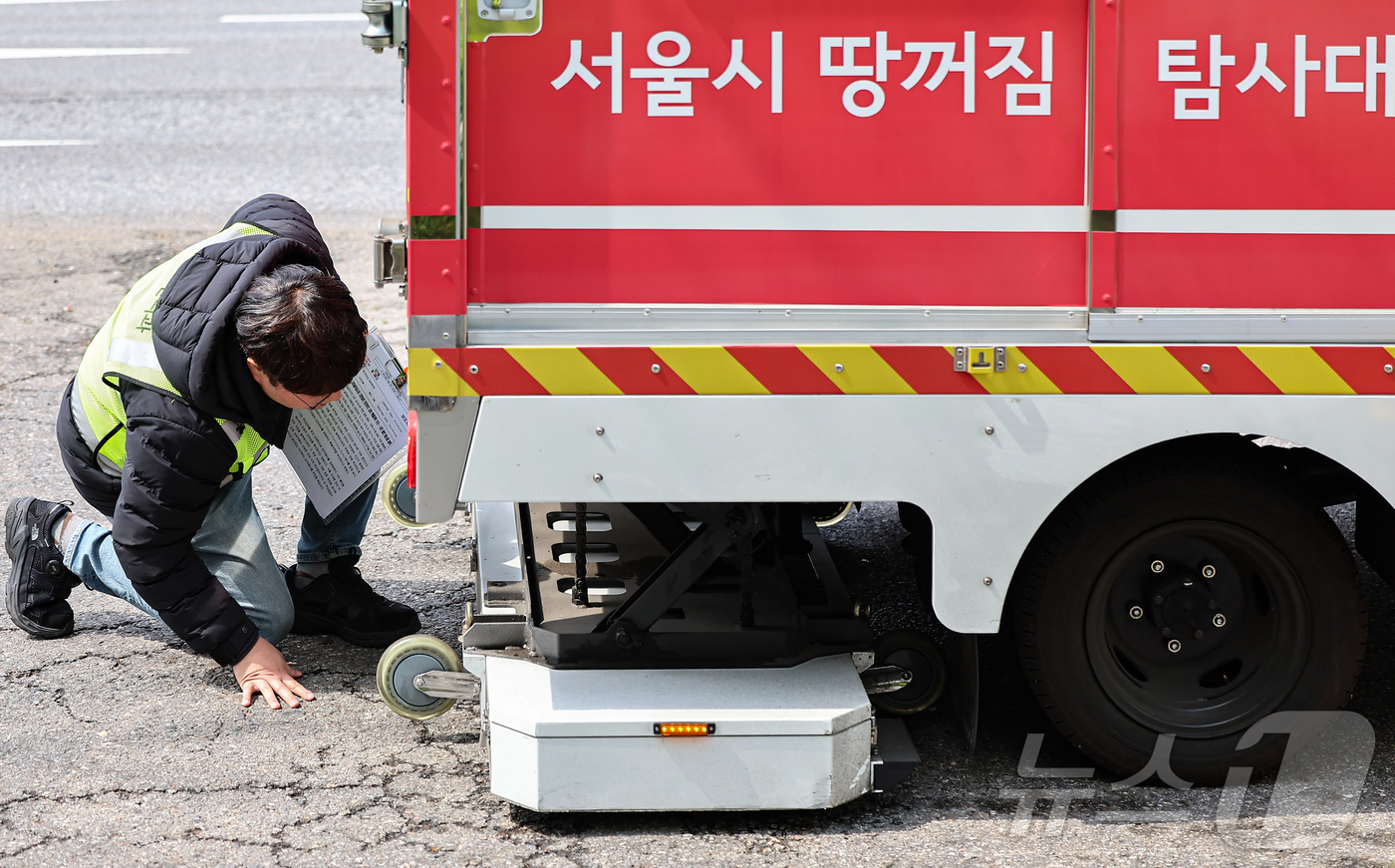 (서울=뉴스1) 김도우 기자 = 15일 서울 시내 한 도로에서 서울시 재난안전실 도로관리과 직원들이 땅꺼짐 탐사대 차량에 실린 장비를 점검하고 있다.서울시는 최근 강동구 명일동 땅 …