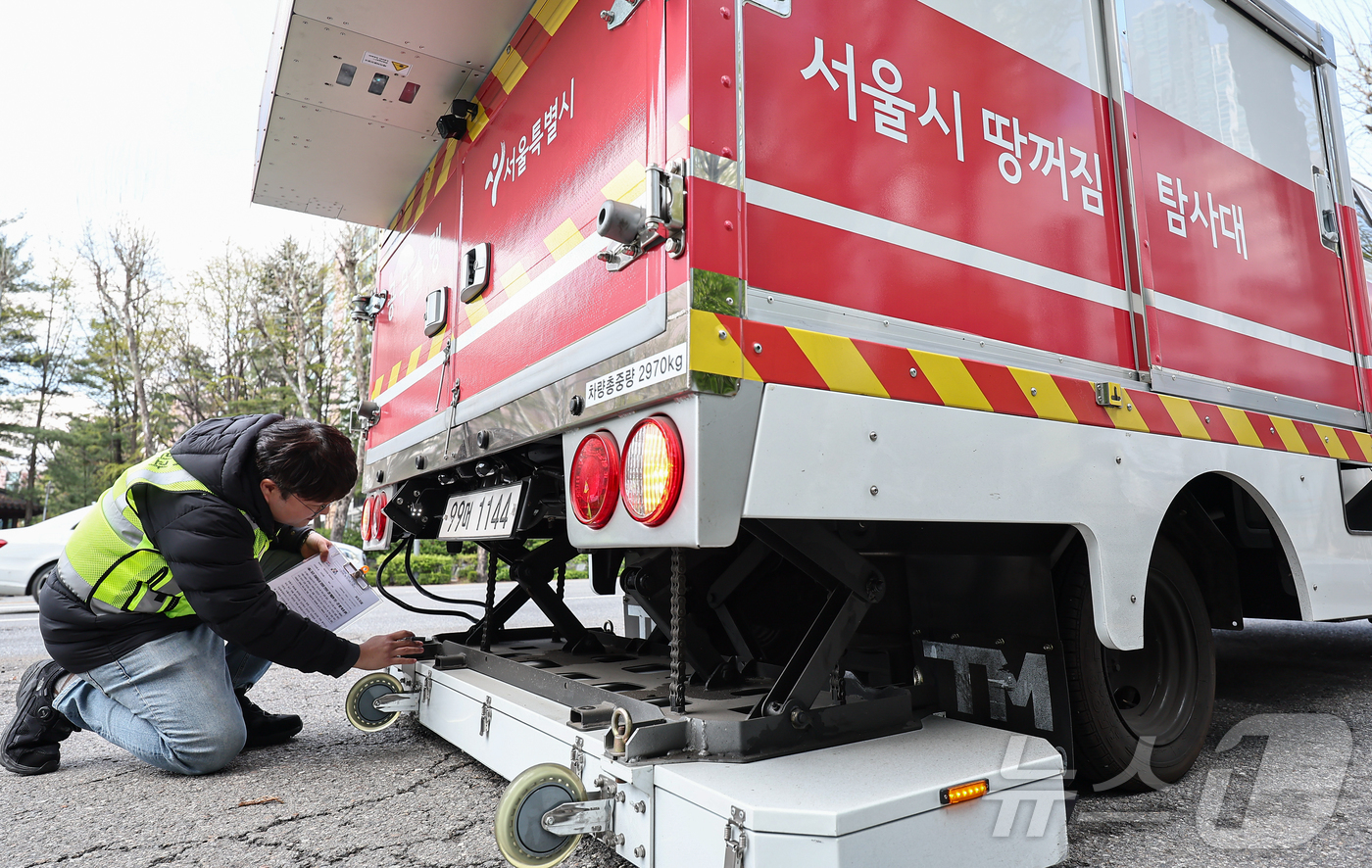 (서울=뉴스1) 김도우 기자 = 15일 서울 시내 한 도로에서 서울시 재난안전실 도로관리과 직원들이 땅꺼짐 탐사대 차량에 실린 장비를 점검하고 있다.서울시는 최근 강동구 명일동 땅 …