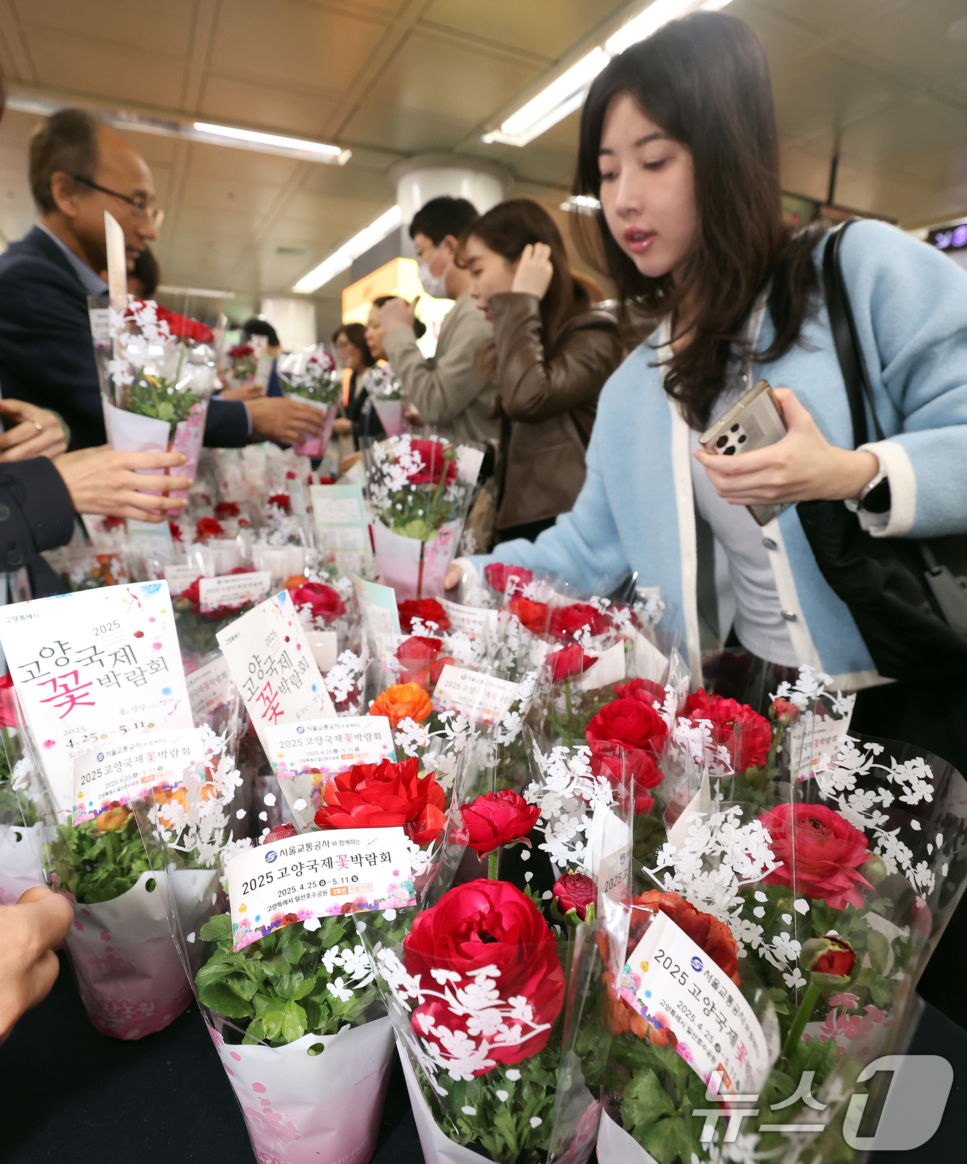 (서울=뉴스1) 오대일 기자 = 서울교통공사 임직원들이 17일 오전 서울 종로구 광화문역 대합실에서 출근길 시민들을 응원하며 '라넌큘러스' 화분 1,000개를 무료 나눔하고 있다. …