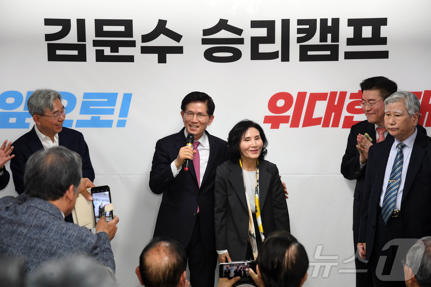 (서울=뉴스1) 김민지 기자 = 국민의힘 대선 경선에 출마하는 김문수 후보자가 17일 오후 서울 여의도 선거사무소에서 열린 개소식에서 인사말을 하던 도중 부인을 소개하고 있다. ( …