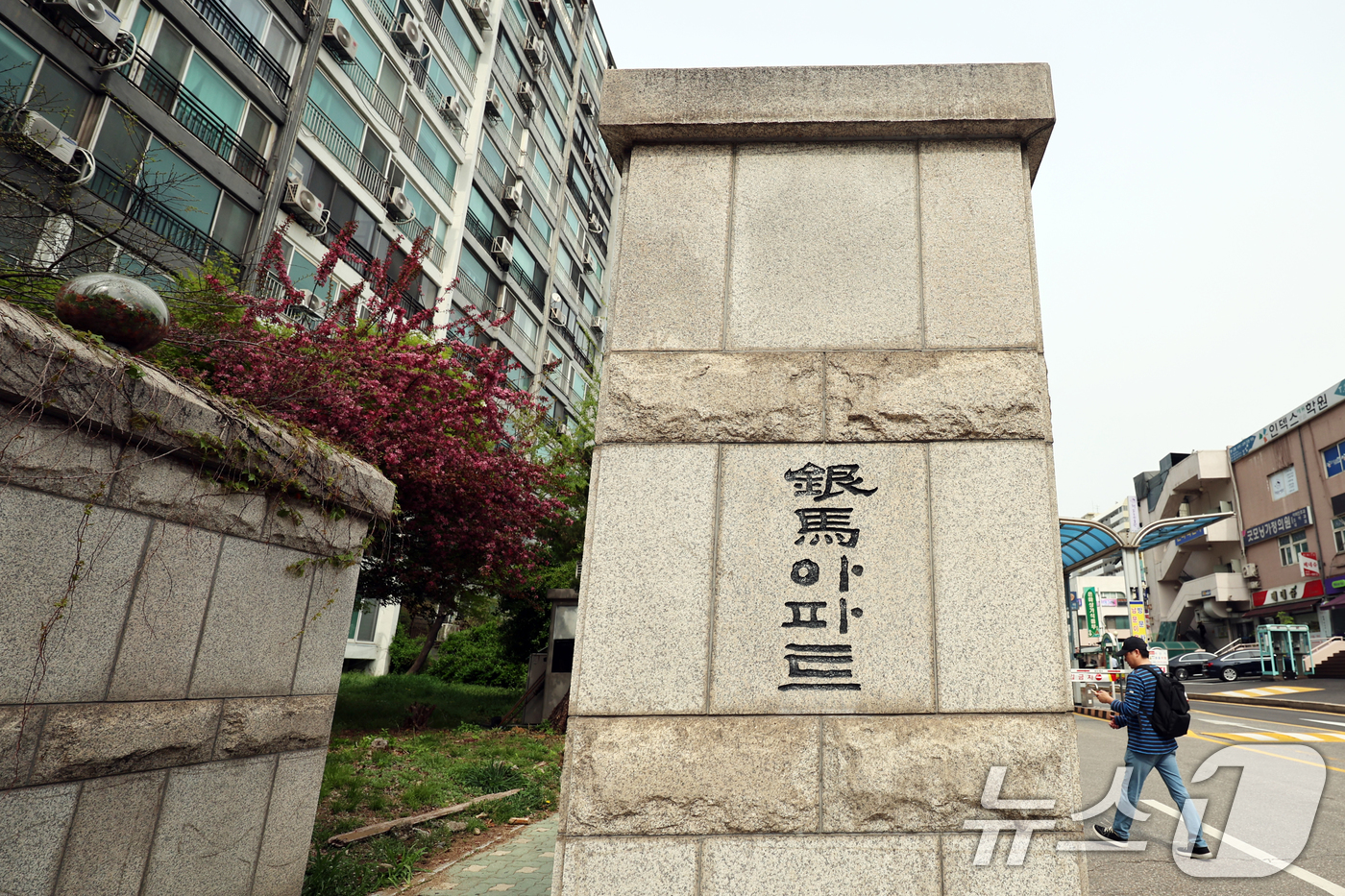 (서울=뉴스1) 황기선 기자 = 17일 서울 강남구 은마아파트 입구 앞으로 시민이 지나가고 있다.강남의 대표 재건축 단지 대치동 은마아파트가 최고 49층, 5962가구 규모의 대규 …