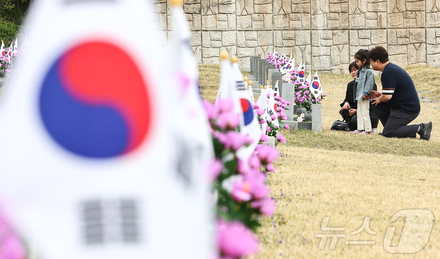 본문 이미지 - 4·19혁명 기념일을 하루 앞둔 18일 서울 강북구 국립 4·19 민주묘지에서 한 부모가 아이에게 4·19 혁명에 대해 알려주고 있다. 2025.4.18/뉴스1 ⓒ News1 김도우 기자