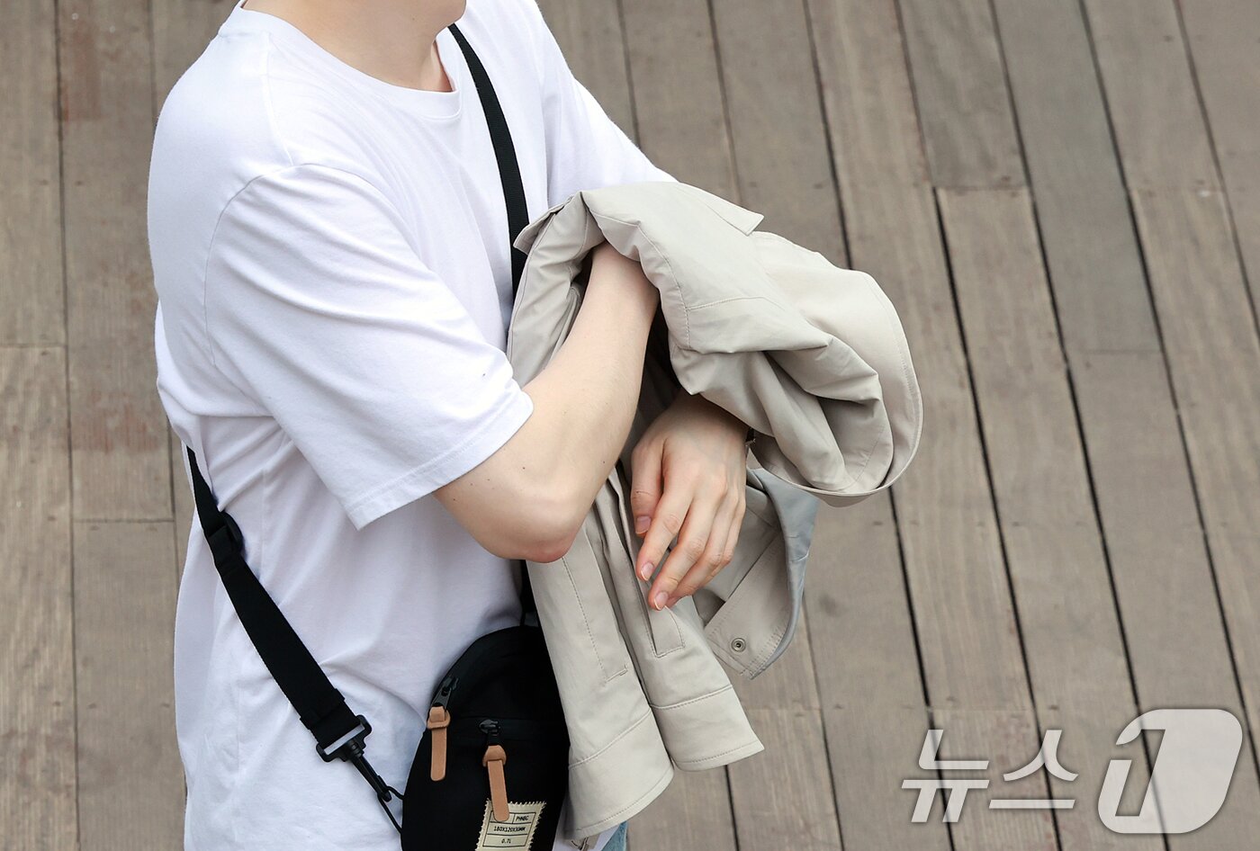 본문 이미지 - 서울의 낮 최고기온이 20도를 기록하는 등 완연한 봄날씨를 보인 18일 오후 서울 중구 남산을 찾은 한 관광객이 외투를 벗고 있다. 기상청은 당분간 따뜻하지만, 일교차가 큰 봄 날씨가 이어질 것으로 내다보고 있다. 2025.4.18/뉴스1 ⓒ News1 김진환 기자