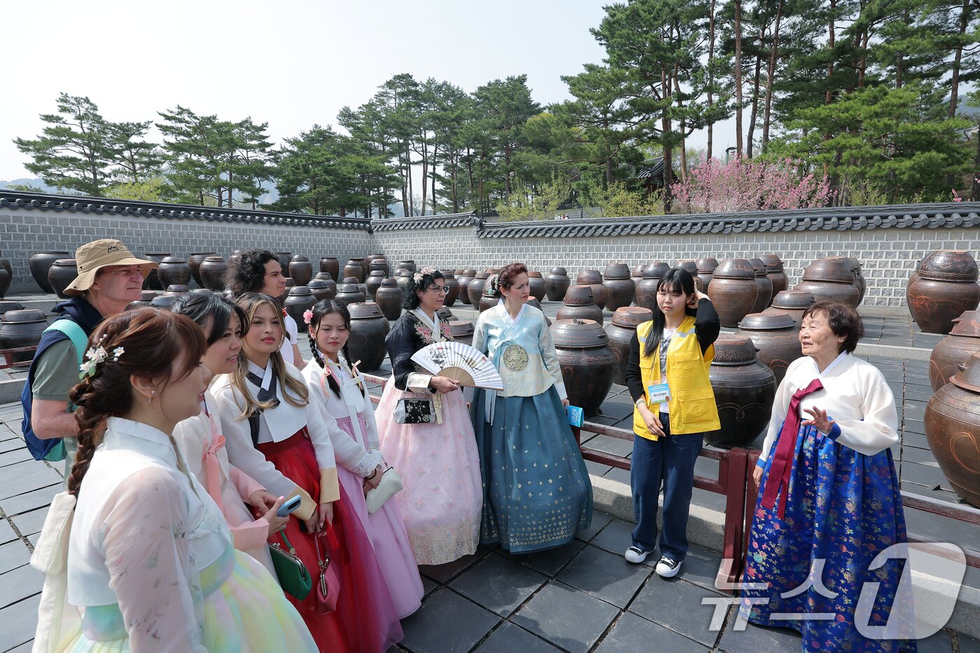 본문 이미지 - 18일 오후 서울 종로구 경복궁 함화당에서 열린 인류무형문화유산 한국의 장 담그기 문화 행사에서 외국인 관광객들이 특별 개방된 경복궁 장고에서 장 담그기에 대한 설명을 듣고 있다.  2025.4.18/뉴스1 ⓒ News1 박정호 기자