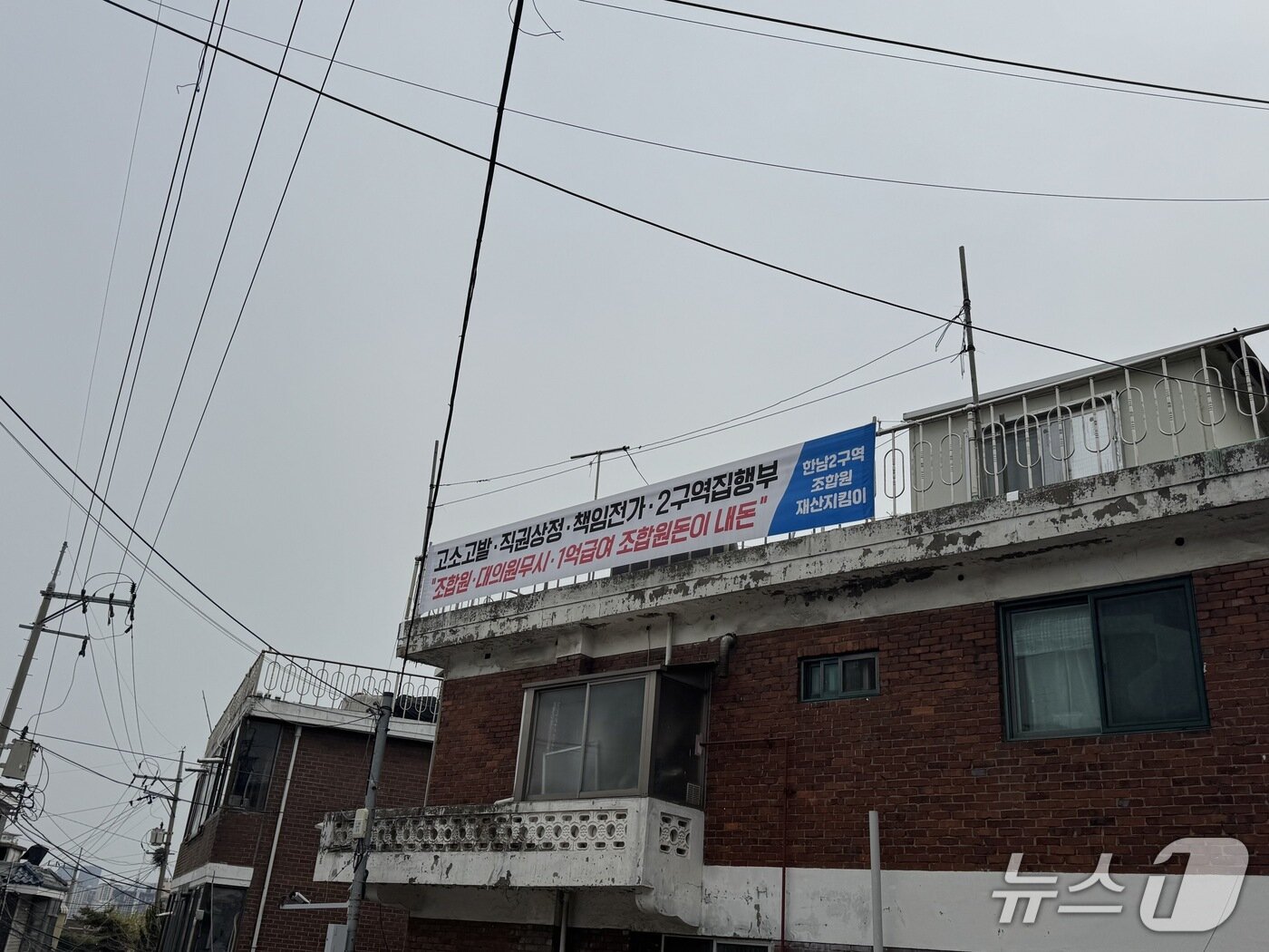 본문 이미지 - 17일 한남2구역의 한 다세대주택 벽면에 시공사 재선정에 반대하는 내용의 현수막이 걸려 있다. 2025.04.18/ 뉴스1 윤주현