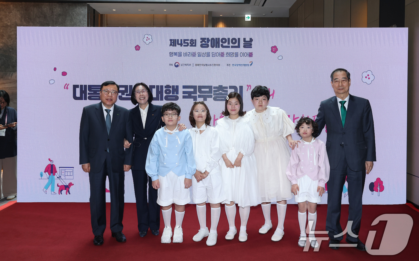 (서울=뉴스1) 임세영 기자 = 한덕수 대통령 권한대행 국무총리가 18일 서울 페어몬트 앰배서더 호텔에서 열린 장애인의 날 기념식에서 장애인 인권헌장 낭독에 나선 아이들과 기념사진 …