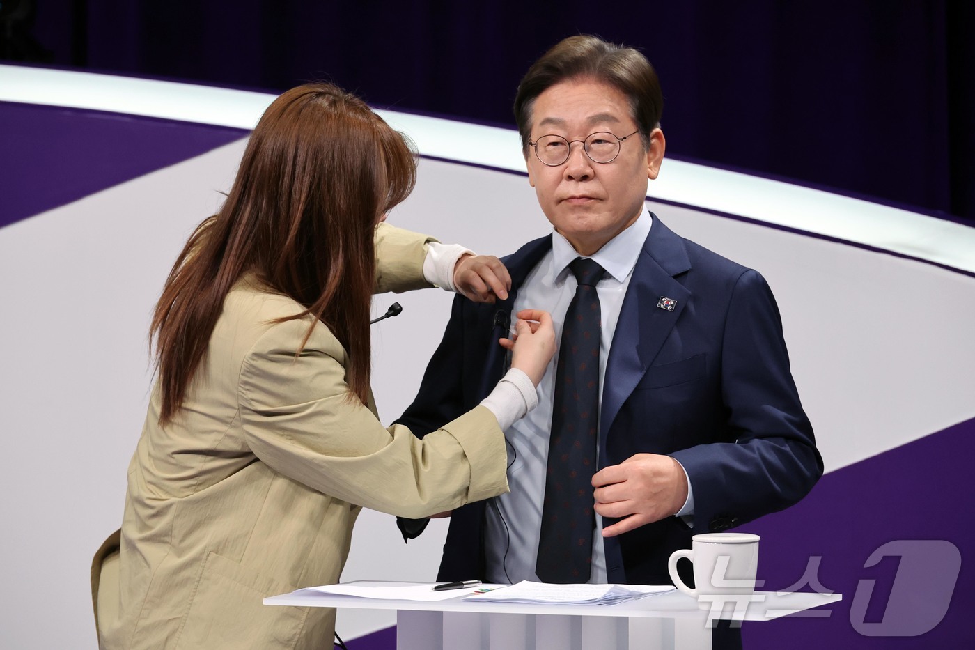 (서울=뉴스1) 국회사진취재단 = 18일 저녁 상암MBC 스튜디오에서 열린 더불어민주당 대선 경선 후보자 첫 TV토론에 참석한 이재명 후보자가 마이크를 착용하고 있다. 2025.4 …