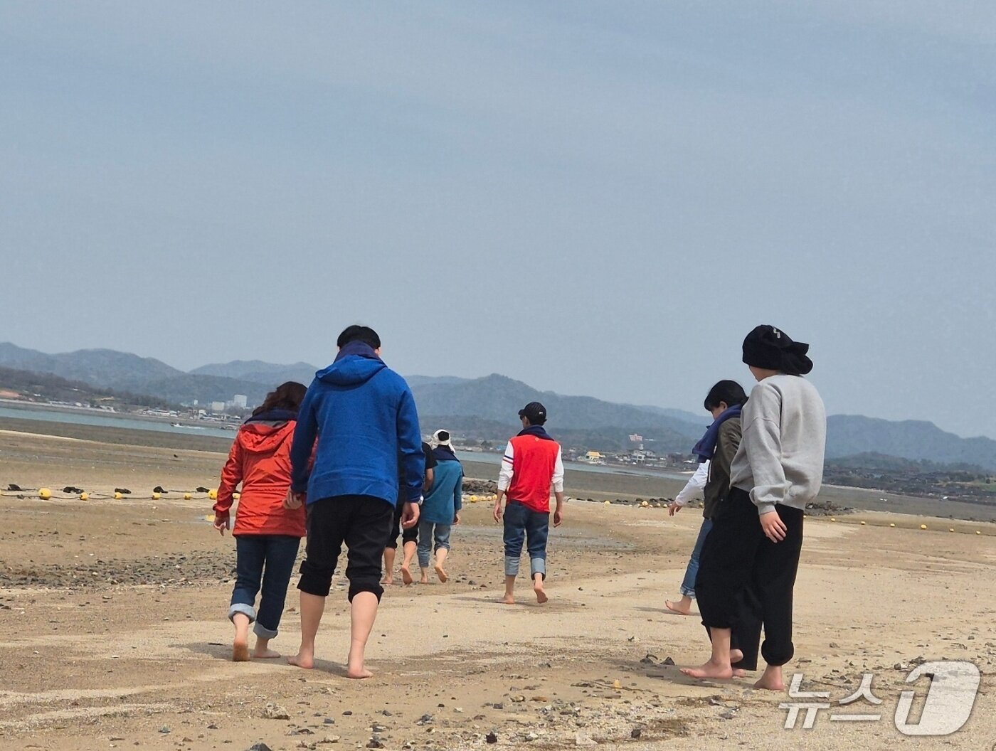 본문 이미지 -  지난 16일부터 이틀간 밀알복지재단은 13명의 시각, 청각 또는 시청각 장애인&#40;장애 당사자&#41;, 활동지원사들과 함께 &#39;오감만족 여행&#39;을 진행했다. 전남 함평 돌머리해수욕장을 거니는 당사자들과 활동지원사들의 모습. 2025.4.17/뉴스1 ⓒ News1 남해인 기자