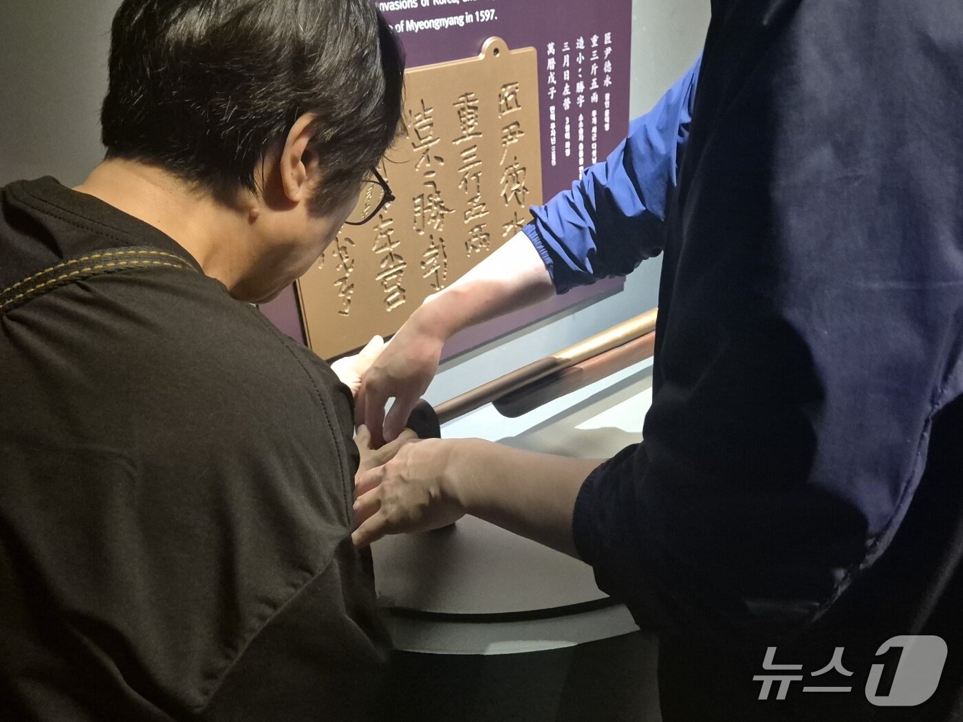 본문 이미지 - 지난 16일부터 이틀간 밀알복지재단은 13명의 시각, 청각 또는 시청각 장애인&#40;장애 당사자&#41;, 활동지원사들과 함께 &#39;오감만족 여행&#39;을 진행했다.  국립해양유산연구소 목포해양유물전시관에서 재단 직원의 도움을 받아 &#39;소소승자총통&#39; 모형을 만져보는 한 당사자의 모습. 2025.4.17/뉴스1 ⓒ News1 남해인 기자