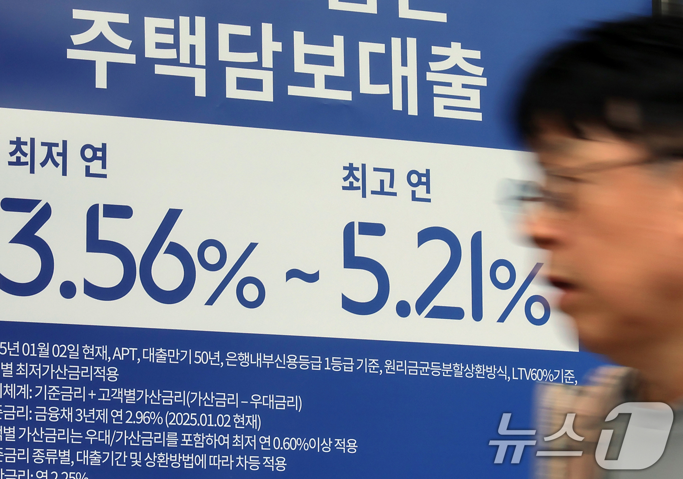 (서울=뉴스1) 박정호 기자 = 가계대출 차주 1인당 평균 대출 잔액이 9천553만 원으로 나타난 2일 서울 시내의 한 은행 입구에 주택담보대출 상품 금리 홍보물 앞으로 시민이 지 …