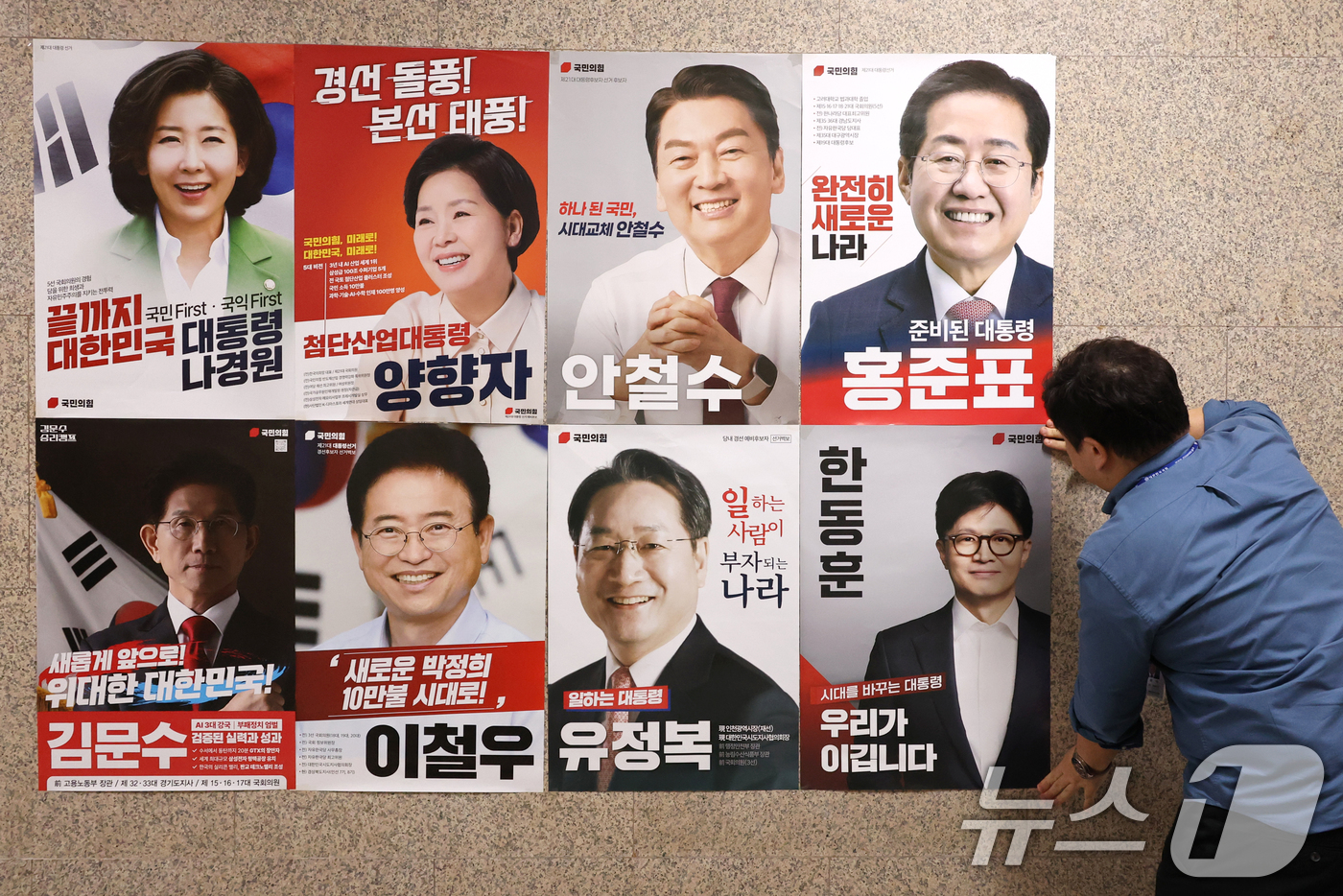 (서울=뉴스1) 이광호 기자 = 20일 오후 서울 여의도 국회 본청 국민의힘 사무실 앞 벽면에 당 관계자가 대선 경선 후보자 포스터를 붙이고 있다. 2025.4.20/뉴스1