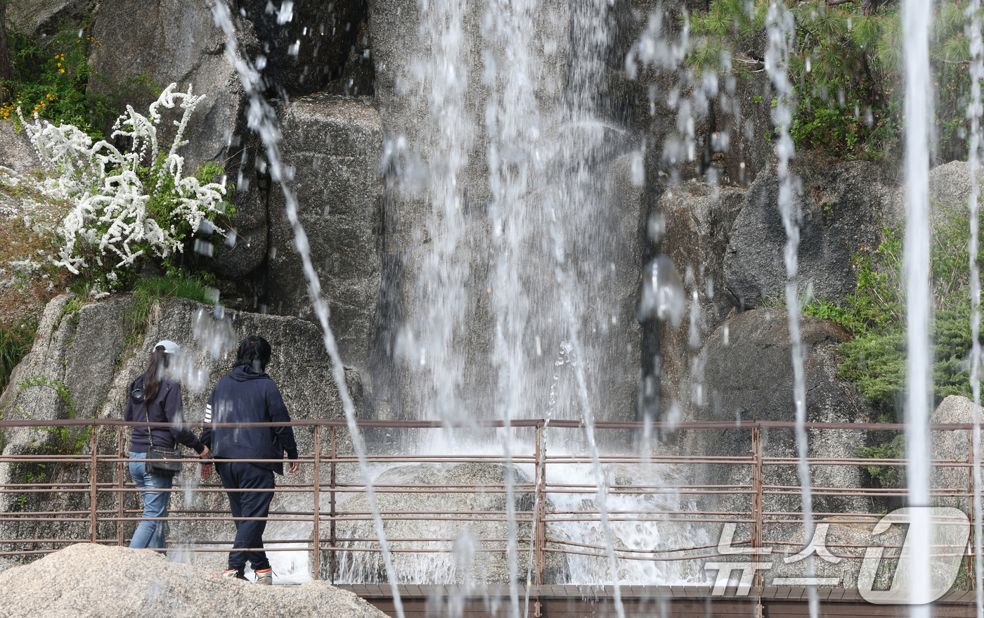 (안산=뉴스1) 김영운 기자 = 낮 최고기온이 26도까지 오르는 등 따뜻한 초여름 날씨를 보인 21일 경기 안산시 상록구 노적봉인공폭포공원을 찾은 시민이 시원한 폭포를 바라보고 있 …