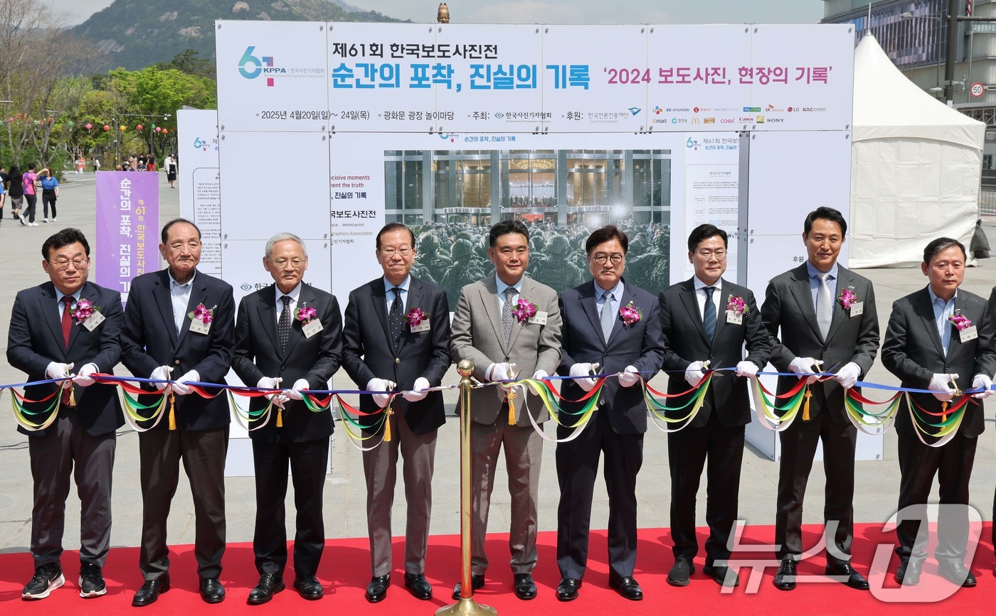 (서울=뉴스1) 사진공동취재단 = 21일 서울 종로구 광화문 광장에서 열린 제61회 한국보도사진전 '순간의 포착, 진실의 기록' 개막식에서 참석자들이 개막을 알리는 커팅식을 하고 …