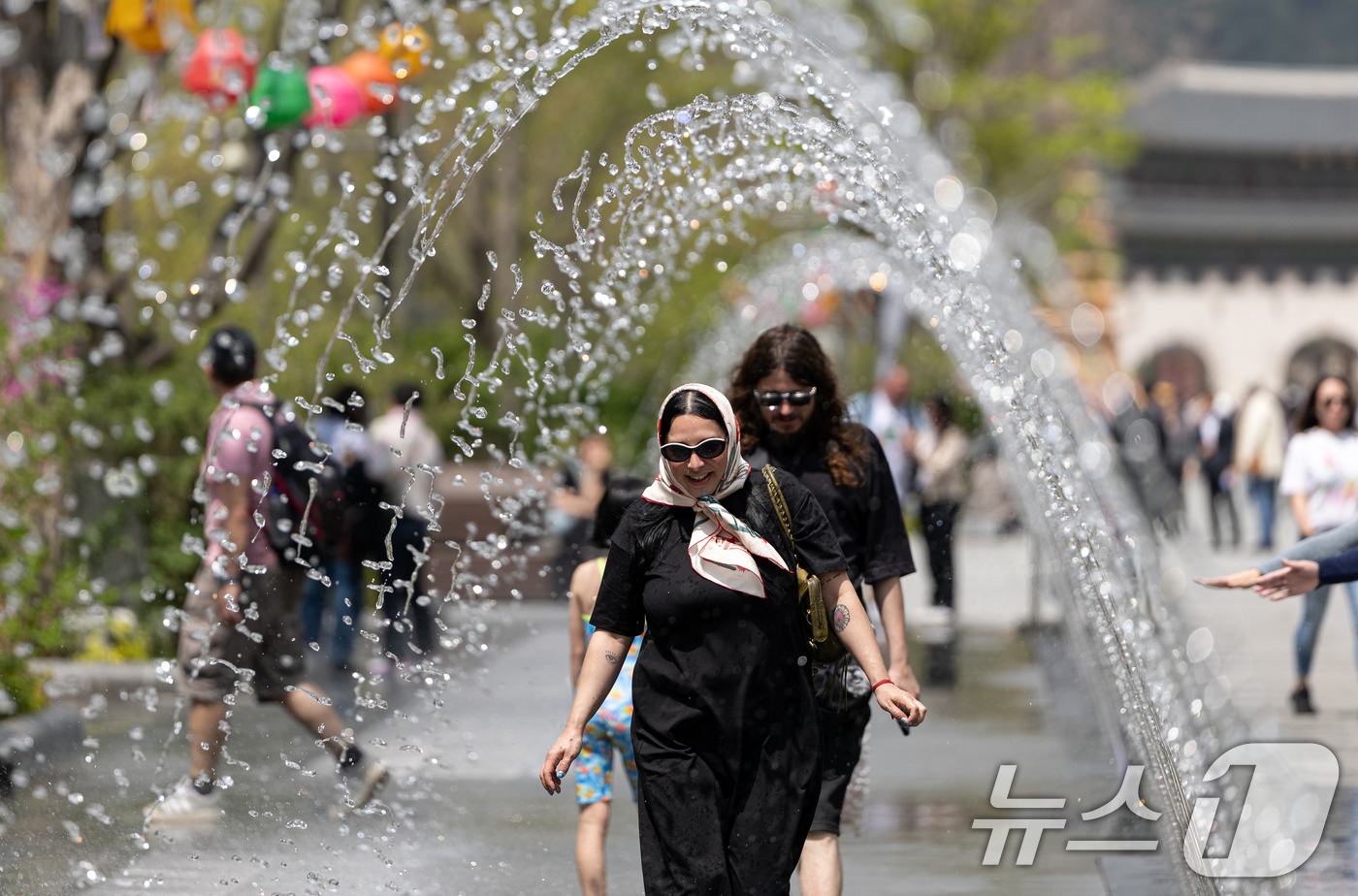(서울=뉴스1) 이승배 기자 = 서울 낮 최고기온이 26도를 기록하는 등 초여름 날씨를 보인 21일 서울 세종대로 광화문광장 터널 분수에서 외국인 관광객들이 더위를 식히고 있다. …