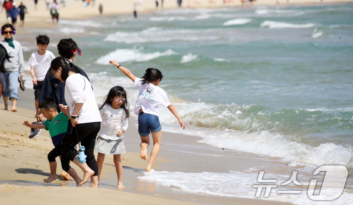 (부산=뉴스1) 윤일지 기자 = 전국적으로 초여름 날씨를 보인 21일 오후 부산 해운대해수욕장을 찾은 외국인 가족이 물놀이를 즐기고 있다.  2025.4.21/뉴스1