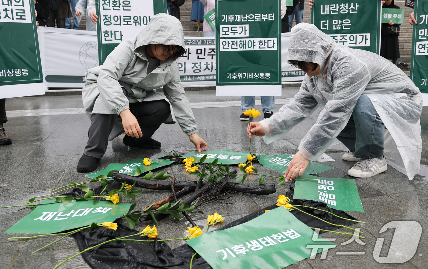 (서울=뉴스1) 임세영 기자 = 기후위기비상행동 관계자들이 22일 서울 종로구 세종문화회관 앞에서 열린 지구의날 기자회견 ‘기후재난과 민주주의 위기, 생명 돌봄의 정치가 필요하다’ …