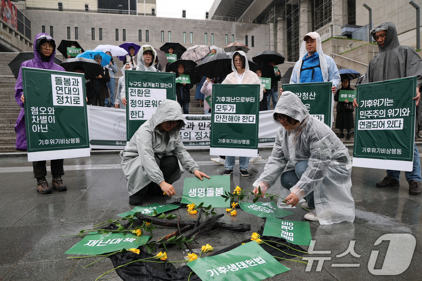 (서울=뉴스1) 임세영 기자 = 기후위기비상행동 관계자들이 22일 서울 종로구 세종문화회관 앞에서 열린 지구의날 기자회견 ‘기후재난과 민주주의 위기, 생명 돌봄의 정치가 필요하다’ …