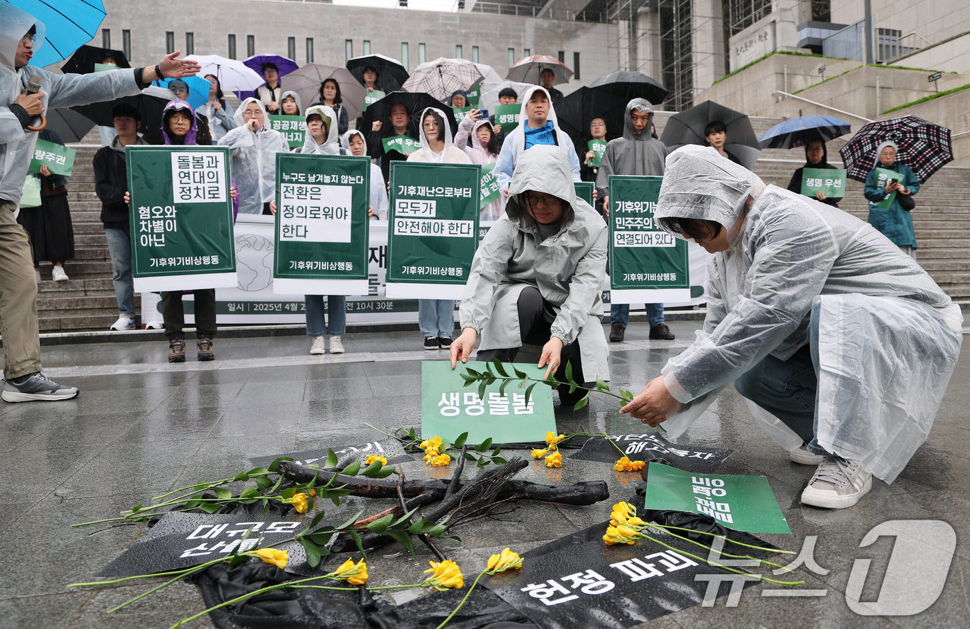 (서울=뉴스1) 임세영 기자 = 기후위기비상행동 관계자들이 22일 서울 종로구 세종문화회관 앞에서 열린 지구의날 기자회견 ‘기후재난과 민주주의 위기, 생명 돌봄의 정치가 필요하다’ …