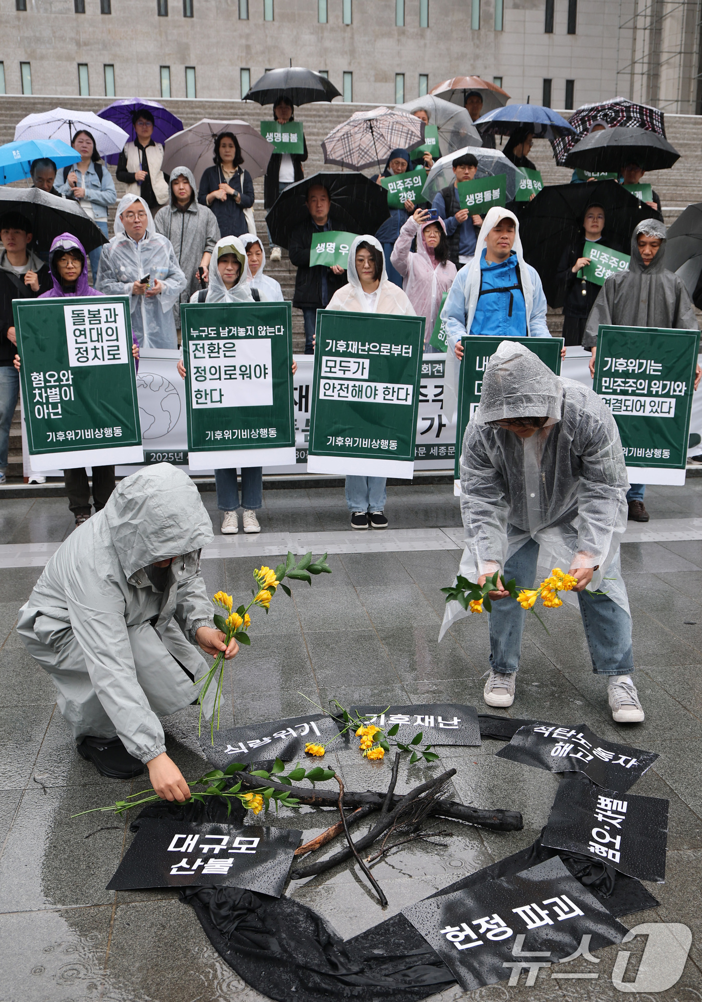 (서울=뉴스1) 임세영 기자 = 기후위기비상행동 관계자들이 22일 서울 종로구 세종문화회관 앞에서 열린 지구의날 기자회견 ‘기후재난과 민주주의 위기, 생명 돌봄의 정치가 필요하다’ …