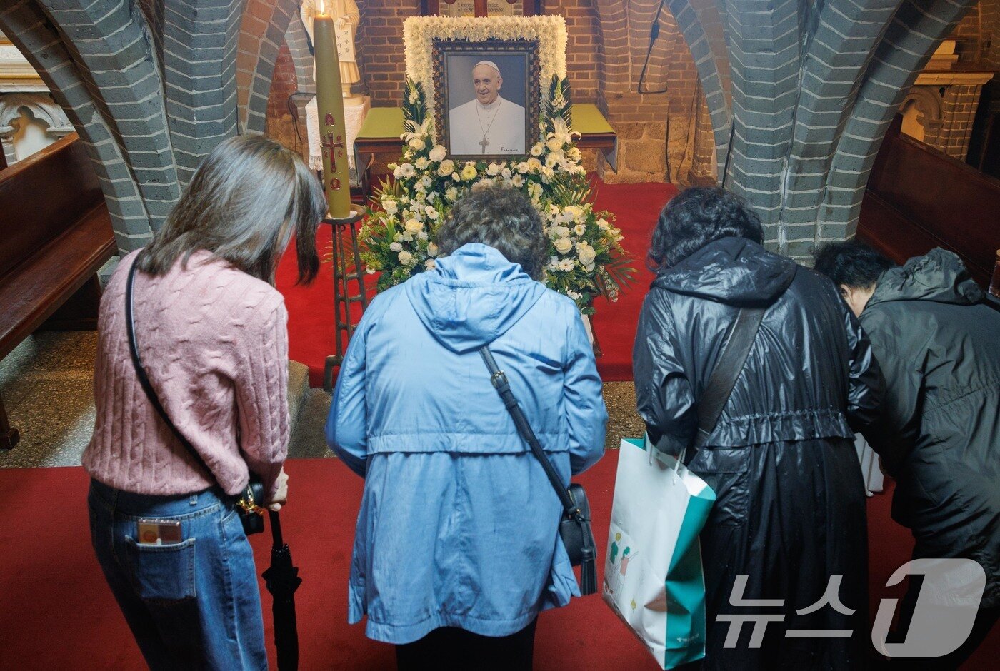 본문 이미지 - 22일 오후 프란치스코 교황의 빈소가 마련된 서울 중구 명동대성당 지하성당에서 조문객들이 추모를 하고 있다. 2025.4.22/뉴스1 ⓒ News1 사진공동취재단