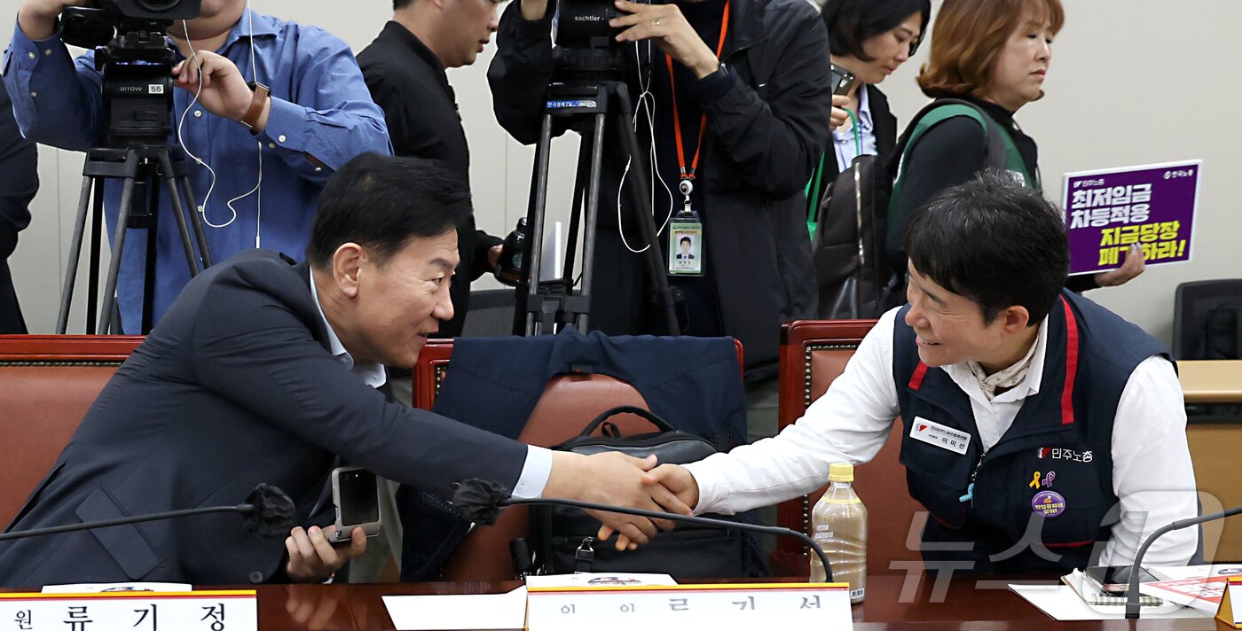 본문 이미지 - 류기정 최저임금위원회 사용자위원과 이미선 근로자위원이 22일 오후 세종시 어진동 정부세종청사 고용노동부에서 열린 2026년 최저임금위원회 제1차 전원회의에 참석하며 악수를 나누고 있다. 2025.4.22/뉴스1 ⓒ News1 김기남 기자