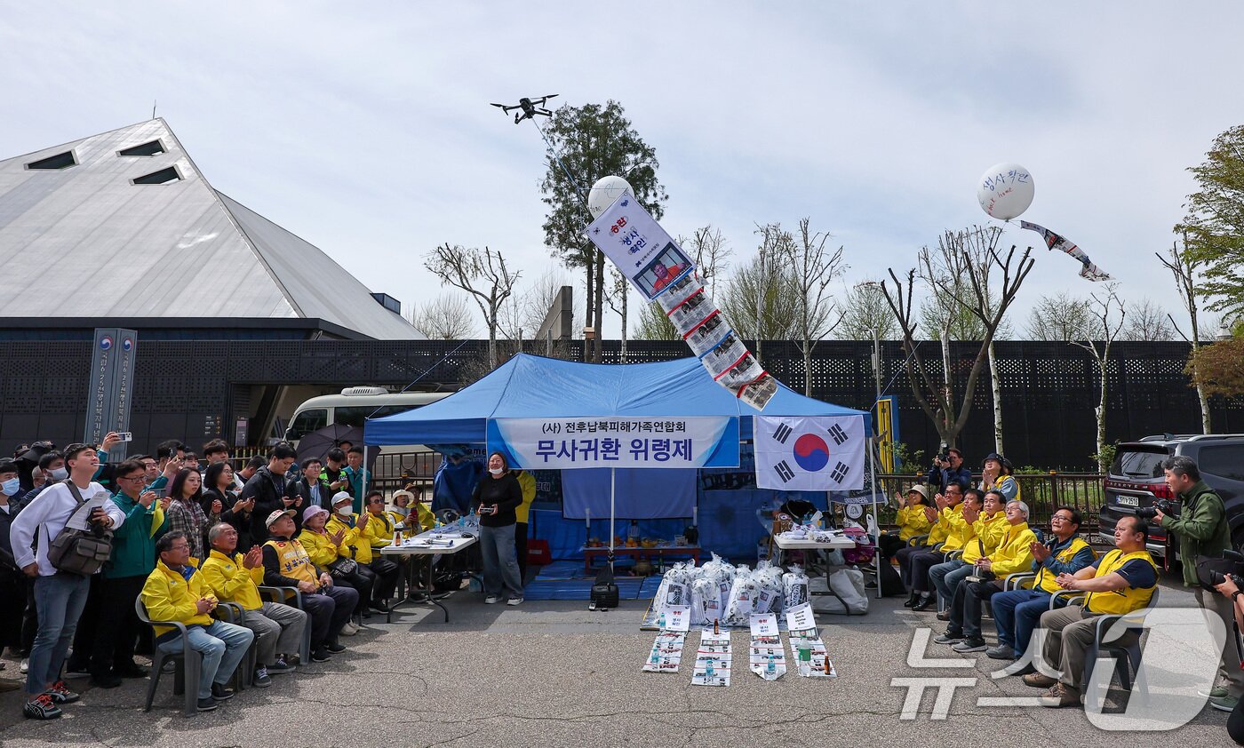 본문 이미지 - 최성룡 납북자가족모임 대표가 23일 경기도 파주시 임진각 평화랜드 인근에서 열린 &#39;무사귀환 위령제&#39; 행사에서 대북전단이 매달린 드론이 떠오르자 박수를 치고 있다. 2025.4.23/뉴스1 ⓒ News1 김성진 기자