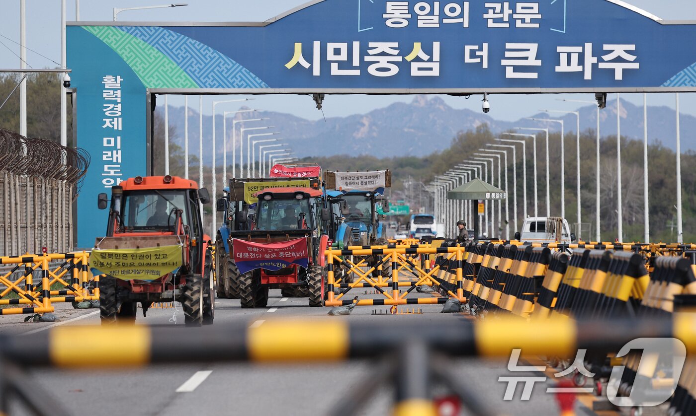 본문 이미지 - 파주 접경지역 주민 등이 23일 오전 경기도 파주시 임진각 평화랜드 인근에서 납북자가족모임 주최로 열리는 대북 전단 살포 행사를 저지하기 위해 트랙터를 이끌고 통일대교에서 나오고 있다. 2025.4.23/뉴스1 ⓒ News1 김성진 기자
