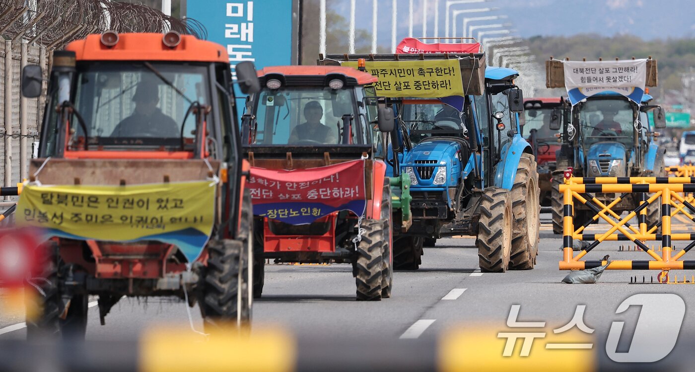 본문 이미지 - 파주 접경지역 주민 등이 23일 오전 경기도 파주시 임진각 평화랜드 인근에서 납북자가족모임 주최로 열리는 대북 전단 살포 행사를 저지하기 위해 트랙터를 이끌고 통일대교에서 나오고 있다. 2025.4.23/뉴스1 ⓒ News1 김성진 기자