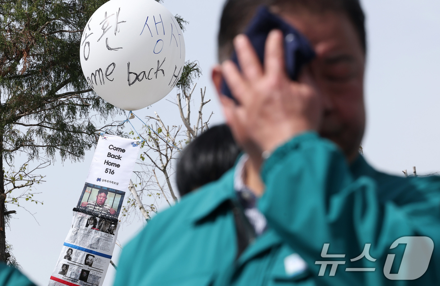 (파주=뉴스1) 김성진 기자 = 23일 경기도 파주시 임진각 평화랜드 인근에서 납북자가족모임 주최로 열린 '무사귀환 위령제' 행사에서 땀을 닦는 김경일 파주시장 뒤로 대형풍선에 매 …