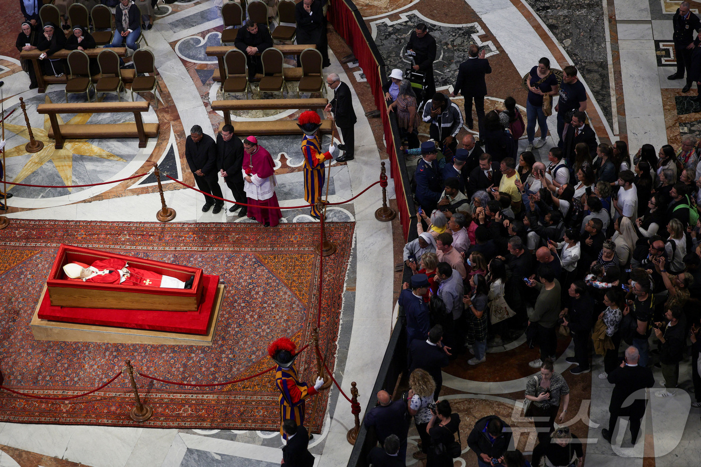 (로이터=뉴스1) = 23일(현지시간) 프란치스코 교황의 관이 안치된 바티칸 성 베드로 대성당에서 신자들이 조문을 하고 있다. 2025.4.23ⓒ 로이터=뉴스1