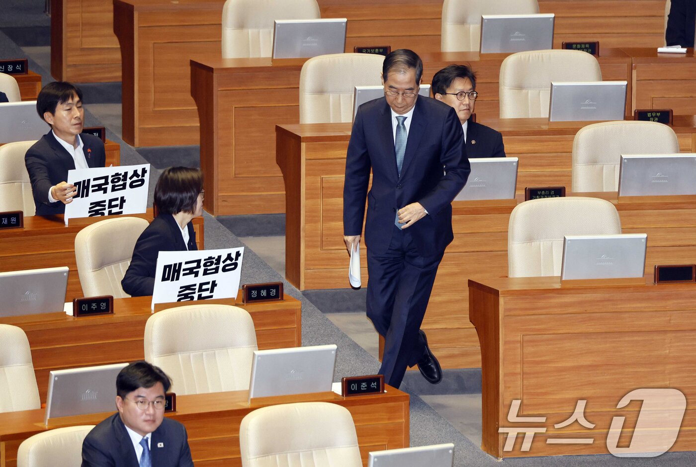 본문 이미지 - 한덕수 대통령 권한대행 국무총리가 24일 국회 본회의장에서 추가경정예산안 시정연설을 하기 위해 단상으로 이동하고 있다. 왼쪽은 '매국협상 중단' 피켓을 든 한창민 사회민주당 대표, 정혜경 진보당 의원. (공동취재) 2025.4.24/뉴스1 ⓒ News1 이재명 기자