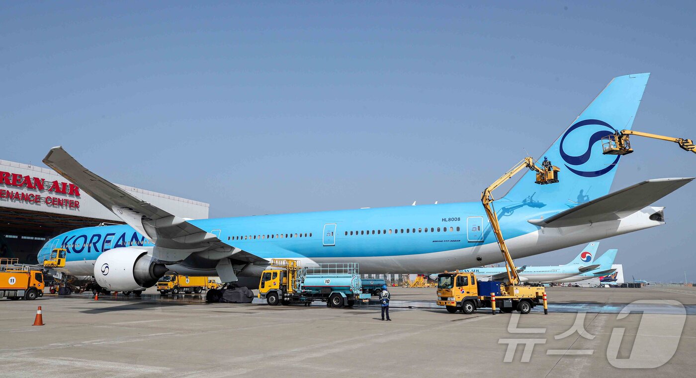 본문 이미지 - 24일 오전 인천 중구 인천국제공항 대한항공 격납고에서 직원들이 봄을 맞아 항공기 동체를 세척하고 있다. 이날 세척한 항공기는 보잉 777-300ER 기종으로 대한항공의 새 도장이 적용된 기체다. (공동취재) ⓒ News1 장수영 기자