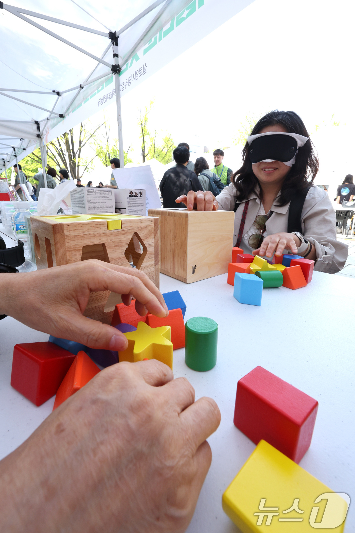 (서울=뉴스1) 신웅수 기자 = 24일 서울 종로구 마로니에 공원에서 열린 종로구 어울누림 축제에서 한 시민이 안대를 쓰고 도형을 맞추는 게임을 체험하고 있다.종로구는 장애에 대한 …
