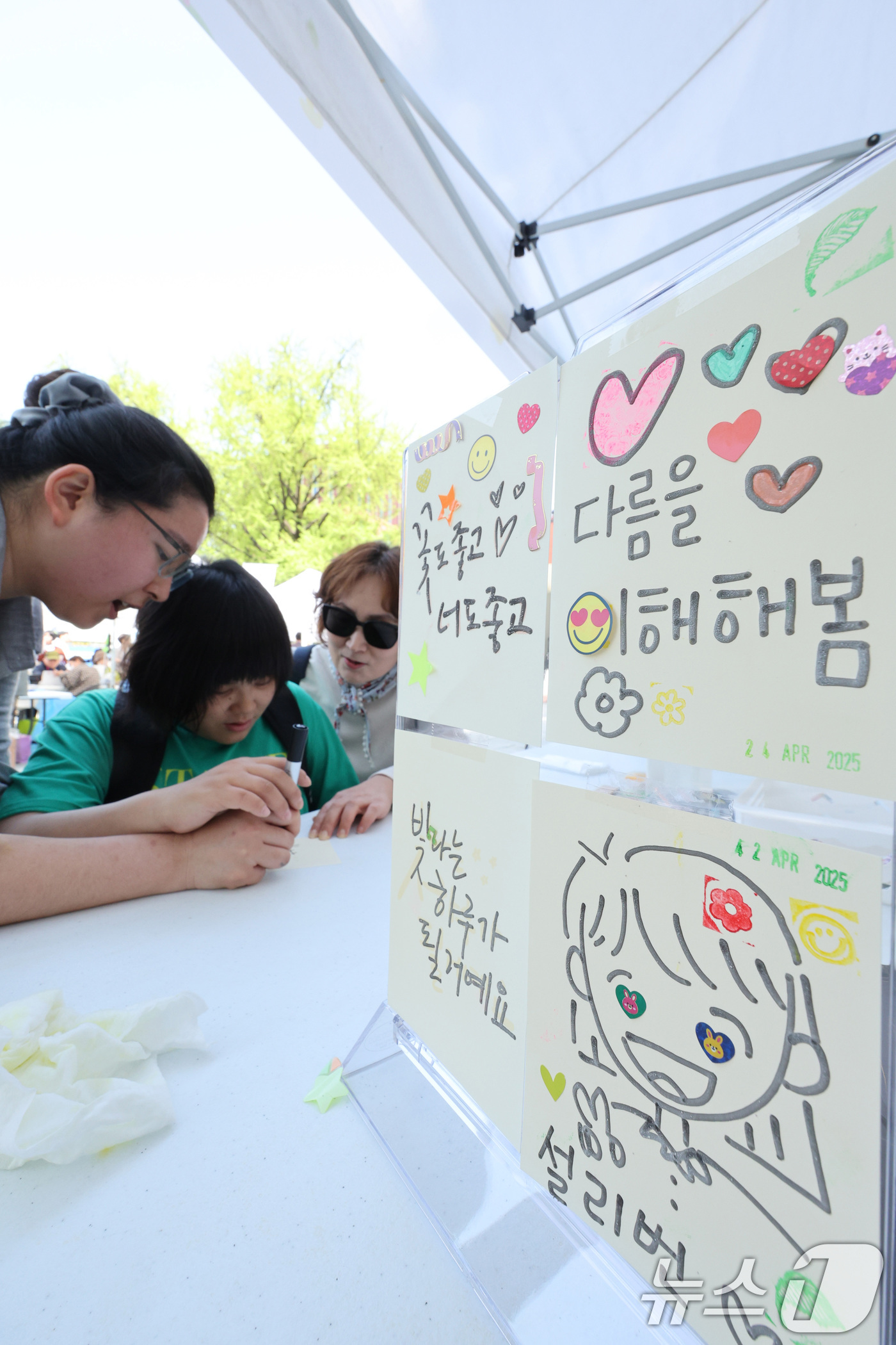 (서울=뉴스1) 신웅수 기자 = 24일 서울 종로구 마로니에 공원에서 열린 종로구 어울누림 축제에서 시민들이 촉각으로 그리는 캘리그라피 체험을 하고 있다.종로구는 장애에 대한 인식 …