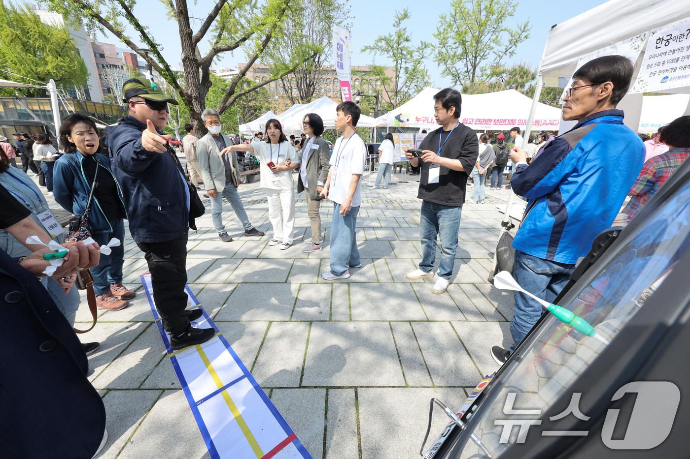 (서울=뉴스1) 신웅수 기자 = 24일 서울 종로구 마로니에 공원에서 열린 종로구 어울누림 축제에서 한 시민이 안대를 쓰고 한궁을 체험하고 있다.종로구는 장애에 대한 인식을 개선하 …