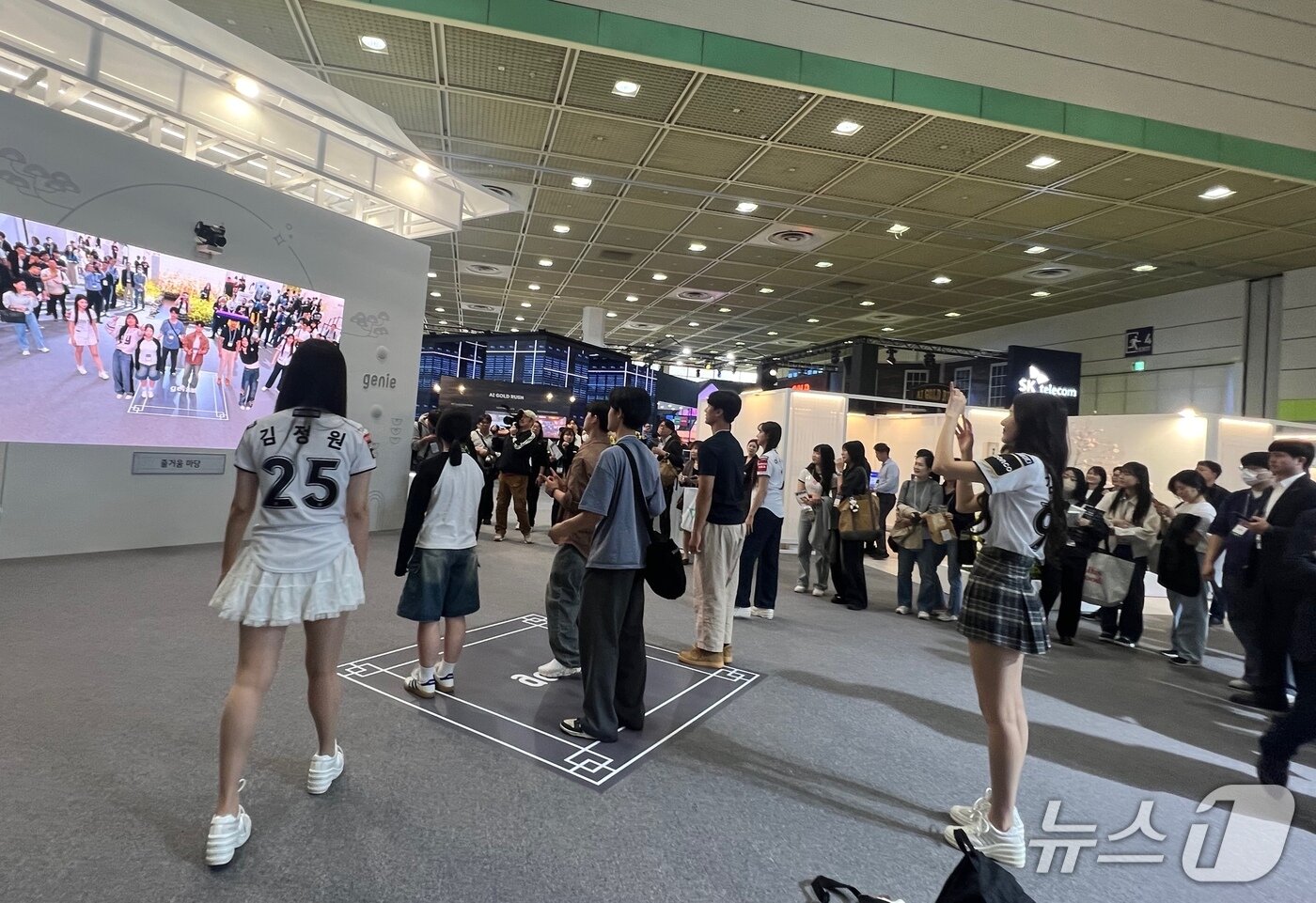 본문 이미지 - KT 부스에서 KT위즈 치어리더와 AI 댄서들이 관람객과 함께 K팝 댄스 챌린지를 진행하고 있다.2025.04.24./뉴스1 ⓒNews1 김정현 기자
