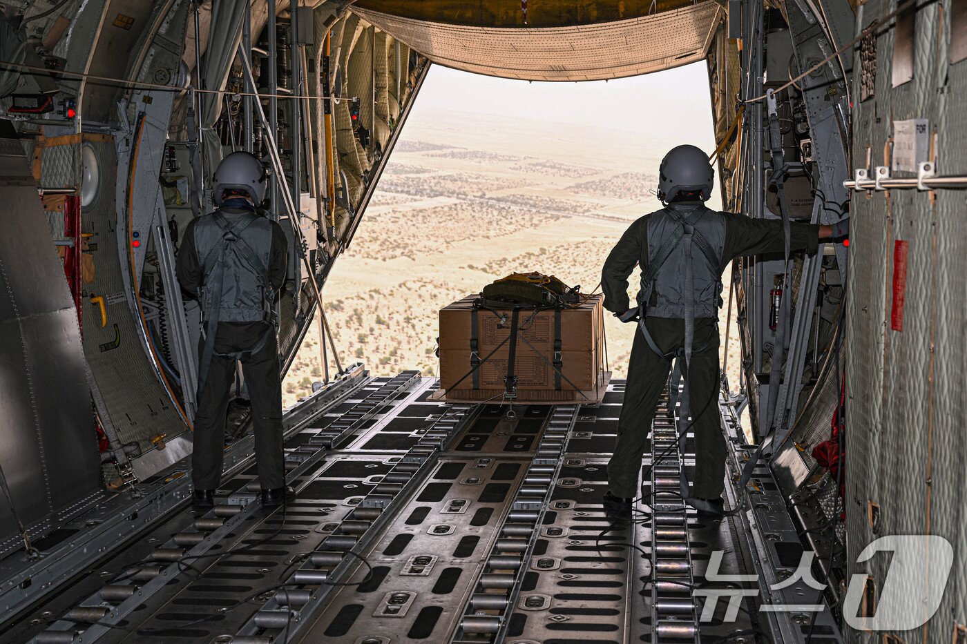 본문 이미지 - 공군은 지난 21일부터 UAE 알 다프라 공군기지에서 열리는 '2025 데저트 플래그'에 참가해 화물 투하, 비포장 활주로 착륙 훈련을 실시하고 있다고 25일 밝혔다. 화물의장사들이 C-130H 수송기 안에서 지상 목표 지점을 향해 화물을 투하하고 있다. (공군 제공. 재판매 및 DB 금지) 2025.4.25/뉴스1