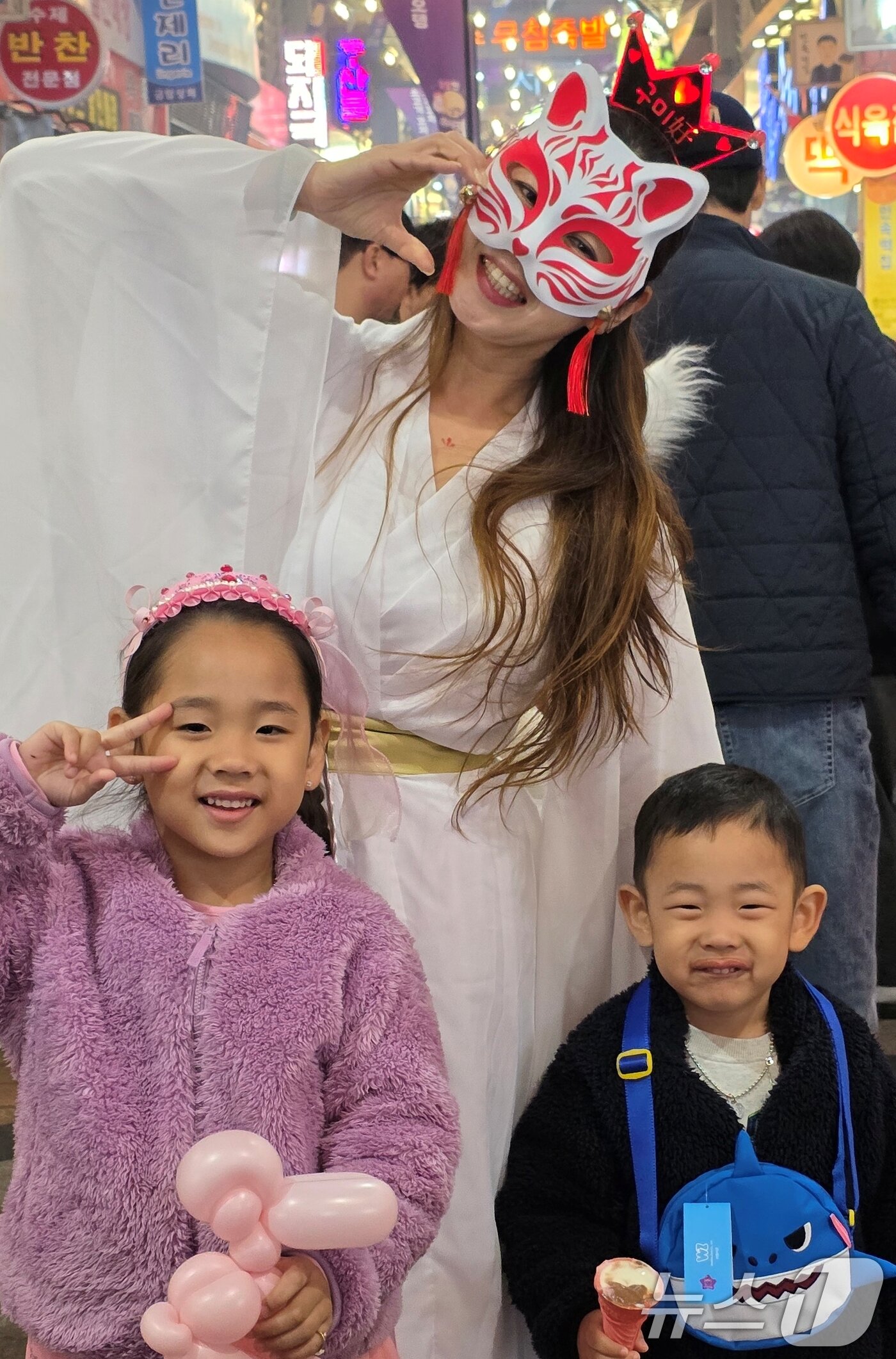 본문 이미지 - 25일 구미 새마을 중앙시장에서 개장한 &#39;달달한 낭만 야시장&#39; 에서 야시장 캐릭터 구미호 걸이 아이들과 기념사진을 찍고 있다. 야시장은 5월17일까지 매주 금·토요일 열리며 5월23~24일과 구미 아시아육상경기선수권대회 기간인 27~31일에는 인동시장에서 문을 연다 2025.4.25/뉴스1 ⓒ News1 정우용 기자