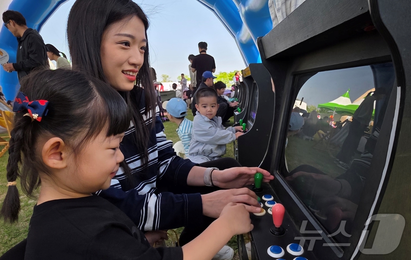 (대구=뉴스1) 정우용 기자 = 26일 구미 낙동강체육공원에서 열린 LG여성배구대회 힐링존에서 한 어린이가 엄마와 함께 옛날 게임을 즐기고 있다.구미 25개 읍·면·동 여성 배구팀 …