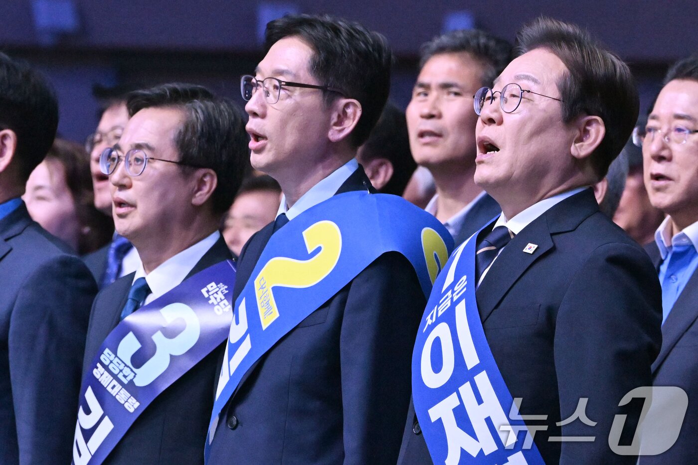 본문 이미지 - 26일 오후 광주 서구 김대중컨벤션센터에서 열린 더불어민주당 21대 대통령선거 후보자 선출을 위한 호남권 합동연설회에서 김동연&#40;왼쪽부터&#41;, 김경수, 이재명 경선 후보가 애국가를 부르고 있다. 2025.4.26/뉴스1 ⓒ News1 김태성 기자