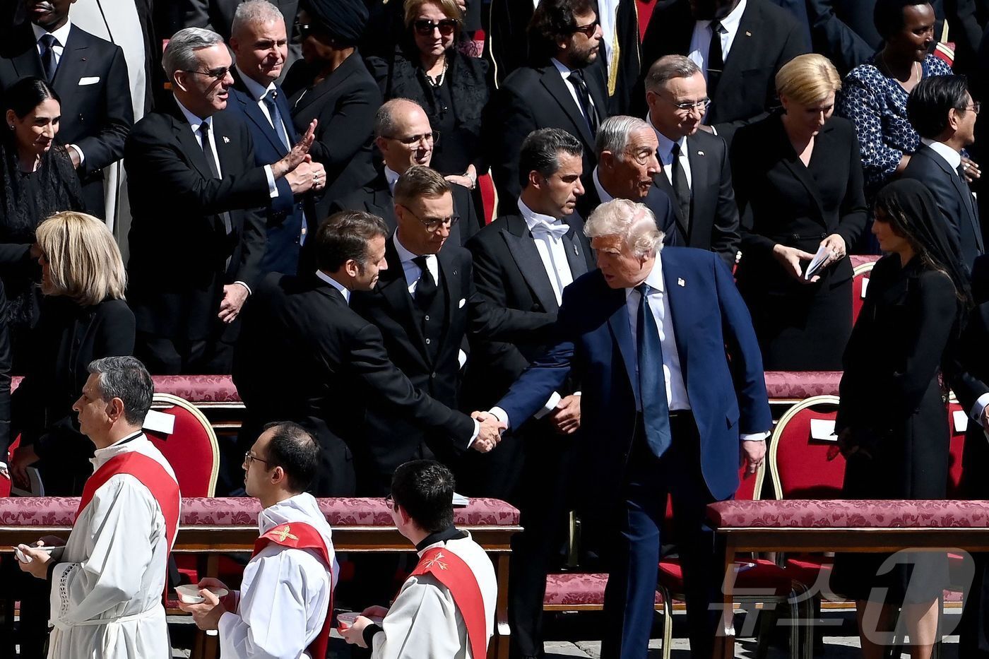 본문 이미지 - 도널드 트럼프 미국 대통령과 에마뉘엘 마크롱 프랑스 대통령이 26일 &#40;현지시간&#41; 바티칸의 성 베드로 광장에서 열린 프란치스코 교황의 장례 미사에 참석해 악수를 하고 있다. 2025.04,27 ⓒ AFP=뉴스1 ⓒ News1 우동명 기자