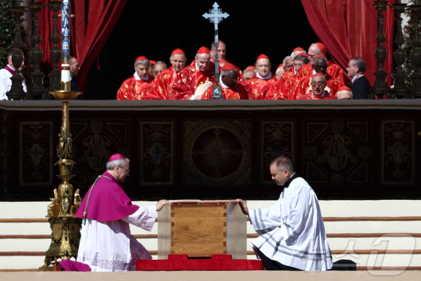 본문 이미지 - 26일 &#40;현지시간&#41; 바티칸의 성 베드로 광장에서 열린 프란치스코 교황의 장례 미사 중 성직자들이 관 옆에 무릎을 꿇고 있다. 2025.04,27 ⓒ 로이터=뉴스1 