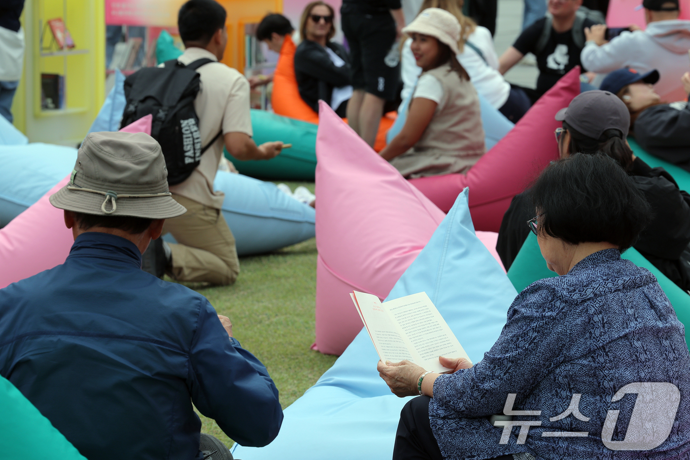 (서울=뉴스1) 박정호 기자 = 포근한 날씨를 보인 27일 서울 광화문 광장에 마련된 서울야외도서관 광화문책마당을 찾은 시민 등이 여유로운 시간을 보내고 있다.  2025.4.27 …